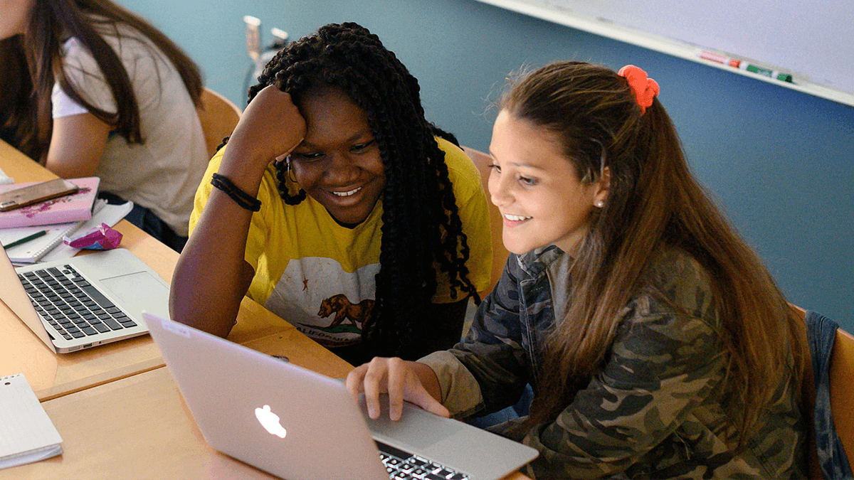 Two girls coding on a computer