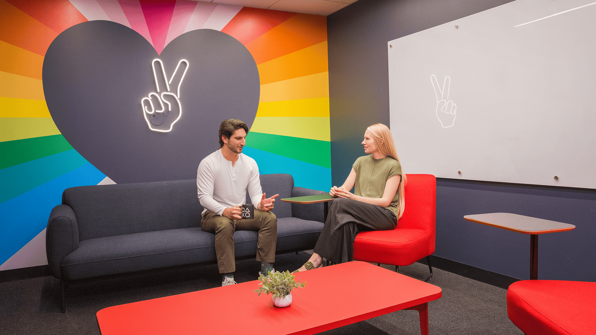 Two Sony Interactive employees chatting in a Sony meeting room.