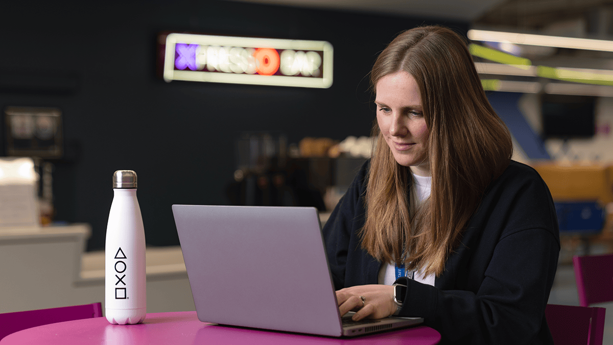 PlayStation employee working at a table on her laptop