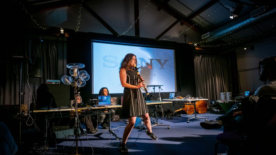 Photo of a woman playing an instrument on a stage