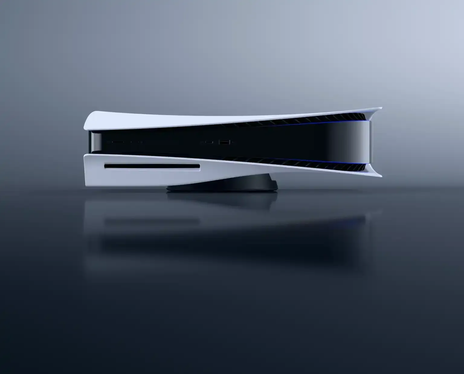 光沢のある表面に横置きされたプレイステーション5。背景はグレー。